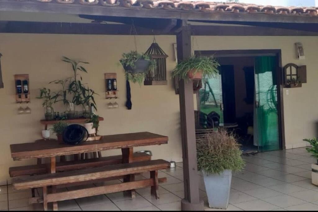 阿拉瓜伊纳Refúgio Aconchegante e Espaçoso的一个带桌子和盆栽植物的庭院
