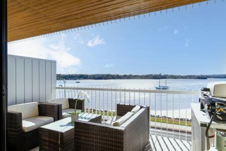 巴特曼斯贝Magnificent 1-Bed with BBQ and Views的享有水景的天井和带家具的阳台。