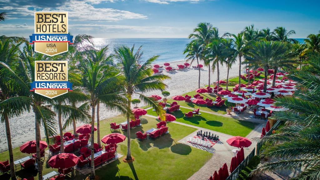 迈阿密海滩Acqualina Resort and Residences的享有带红伞和海滩的度假村的顶部景致