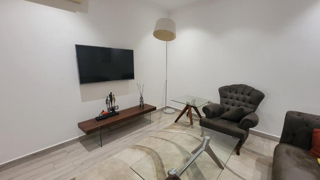 阿克拉Acasia Luxury Home Cantonment的客厅配有两把椅子和电视