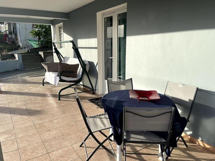 圣吕斯Appartement tout équipé proche des plages的庭院配有椅子和一张桌子及红色枕头