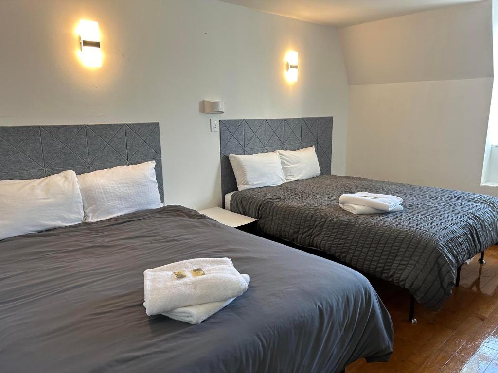 蒙特利尔APD HOTEL的两张位于酒店客房的床,配有毛巾