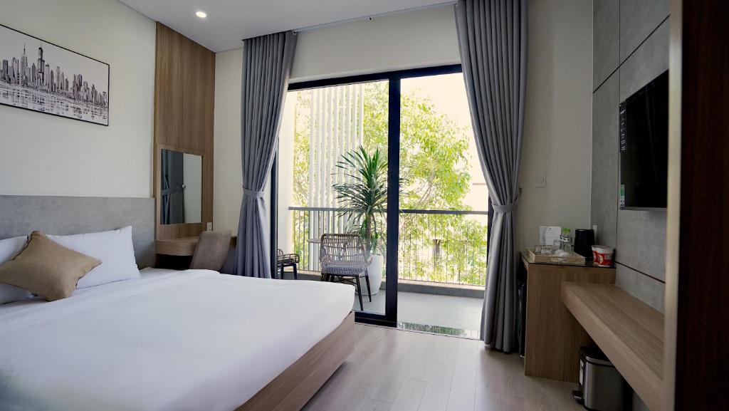 邦美蜀Thành Thuý Hotel的酒店客房设有一张床和一个大窗户