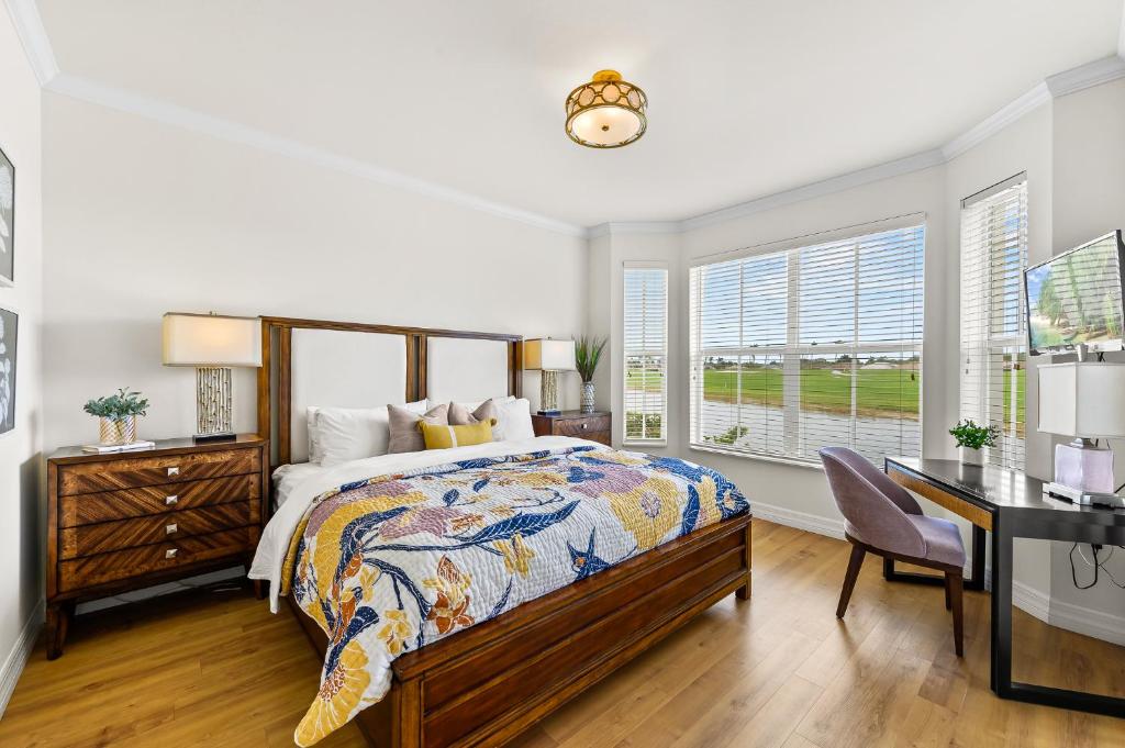 那不勒斯Catina Golf Condo at the Lely Resort的一间卧室配有一张床、一张书桌和一个窗户。