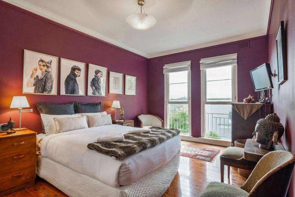 悉尼Great Gatsby Style in the Heart of Double Bay的一间卧室设有紫色的墙壁和一张大床