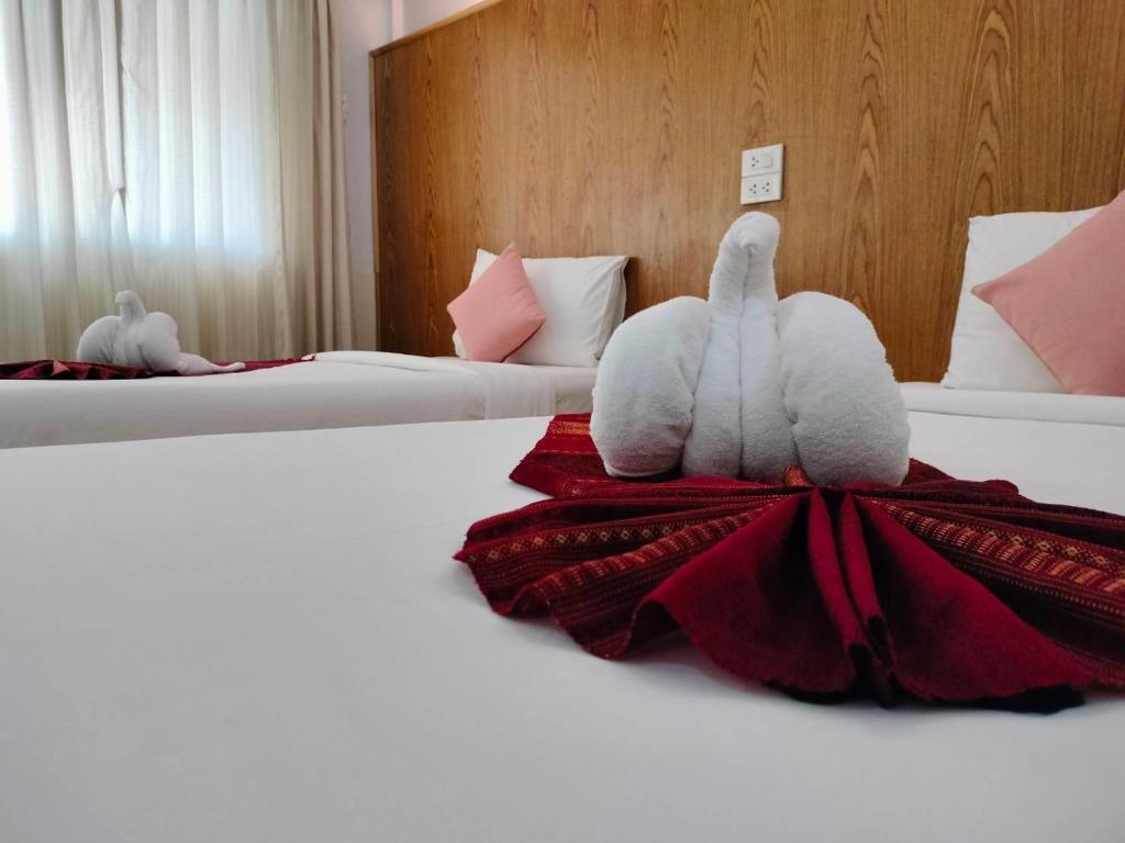 董里S2S皇后庄酒店的两个塞满食物的动物坐在酒店房间里的床边