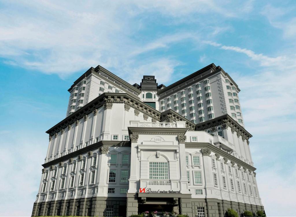 马六甲Grand Swiss-Belhotel Melaka - formerly LaCrista Hotel Melaka的一座白色的大建筑,背后是天空