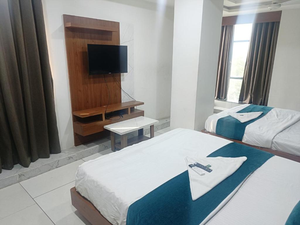 巴罗达ROYAL PRIME HOTEL的酒店客房设有两张床和电视。