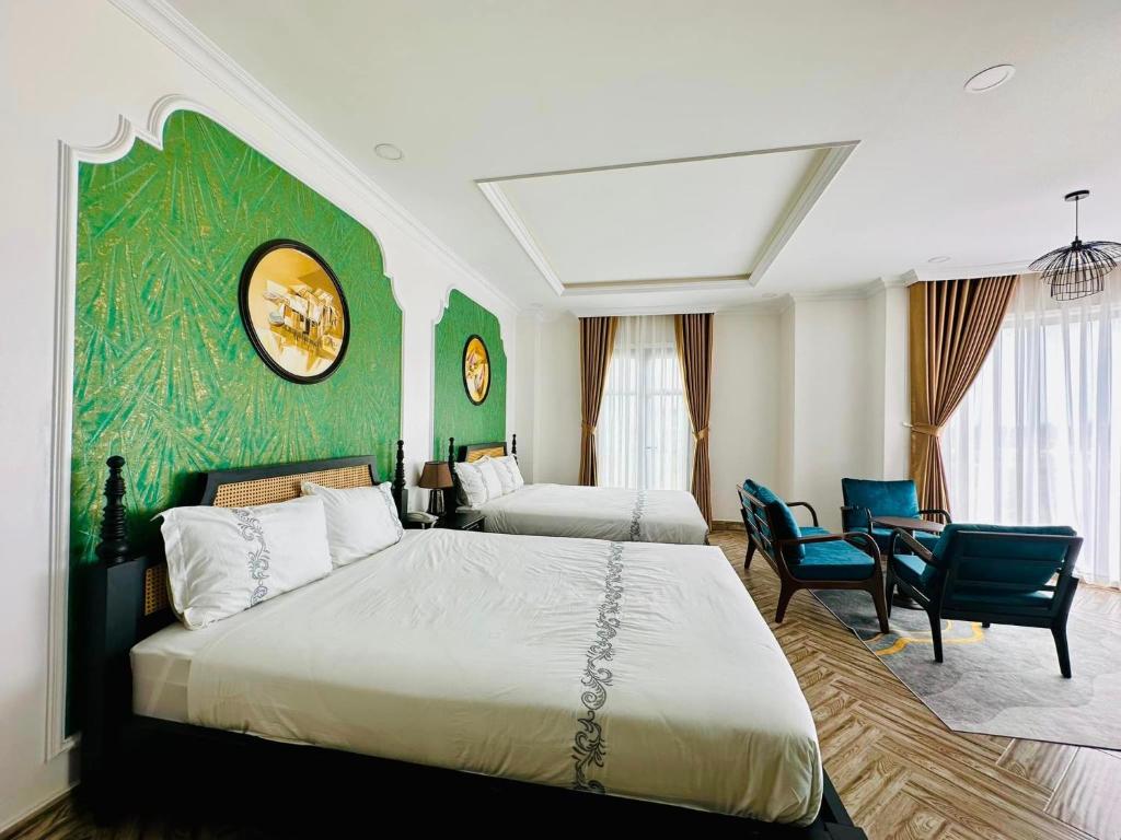 金瓯Khách Sạn The One Hotel 2的一间卧室设有两张床和绿色的墙壁