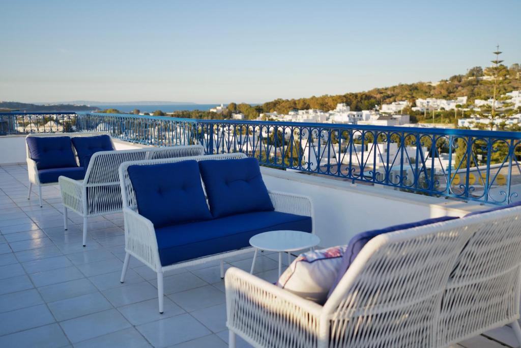 西迪·布·赛义德Misk Villa - Boutique Hotel & Spa的阳台上的一排桌椅
