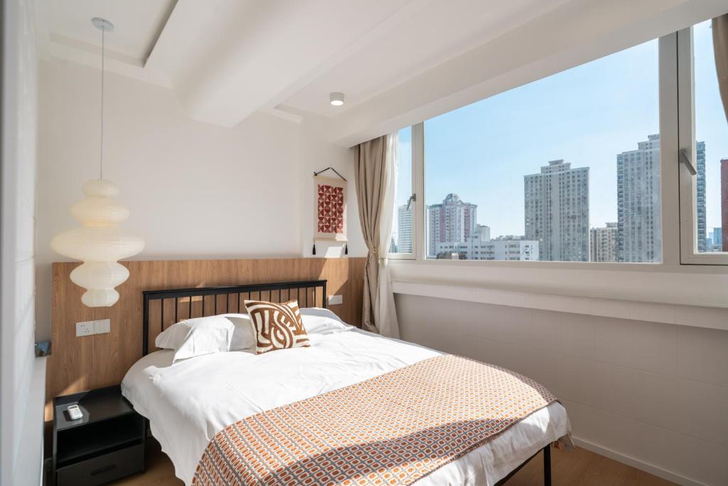 上海上海市中心壹度民宿 -嘉善路地铁站5号口步行150米的一间卧室设有一张床和一个大窗户