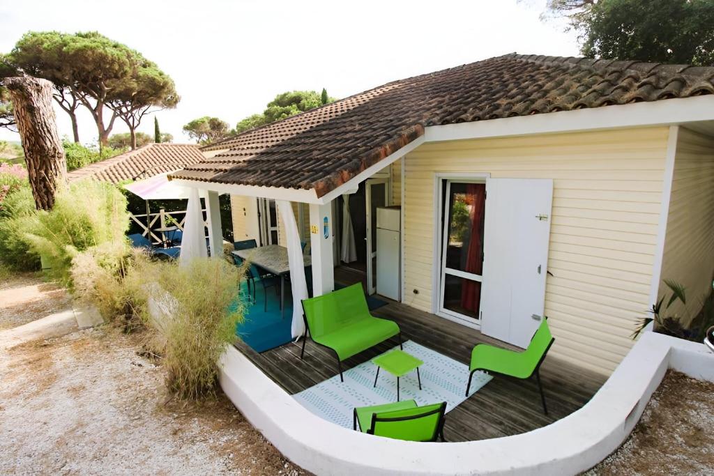 加桑GASMIM29 - Golfe de St-Tropez, chalet climatisé dans domaine arboré的一座带甲板和绿色椅子的房子