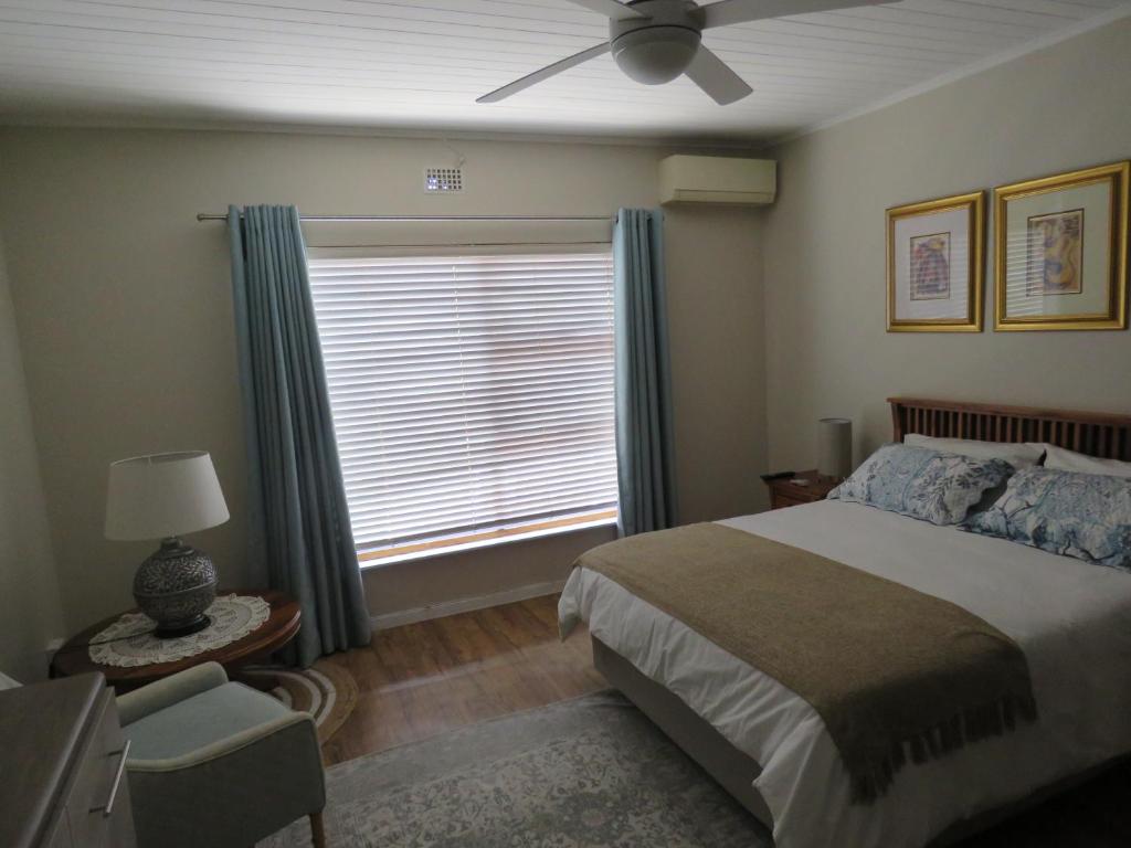帕尔Avo Tree Guesthouse的一间卧室设有一张床和一个带吊扇的窗户。