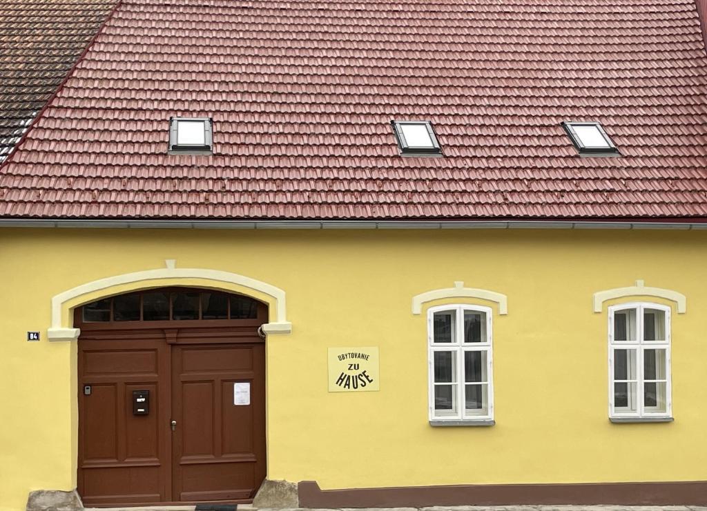 韦伯夫Zu Hause的黄色的建筑,有棕色的门和红色的屋顶