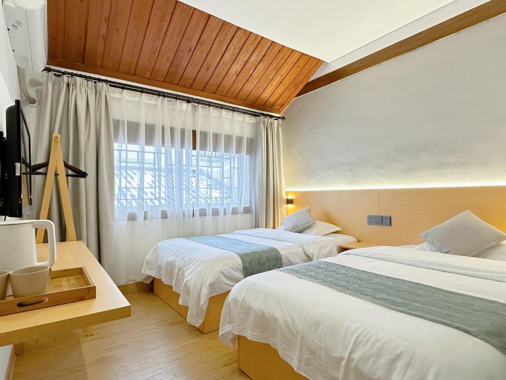 凤凰凤凰古城Hemu House的酒店客房设有两张床和窗户。