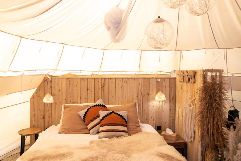 LembekeComfort Tipi Marie, Tipi Bo Deluxe & tent Nicolaï - 'Glamping in stijl'的帐篷内一间卧室,配有一张床