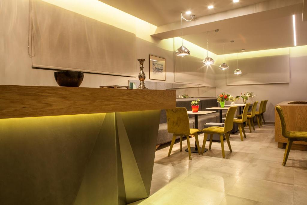 纳夫普利翁阿尼莫斯客房和公寓旅馆的餐厅设有酒吧,配有椅子和桌子