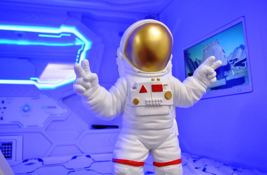 伦敦Cosmos capsule coworking London的穿宇航员服的男人举手