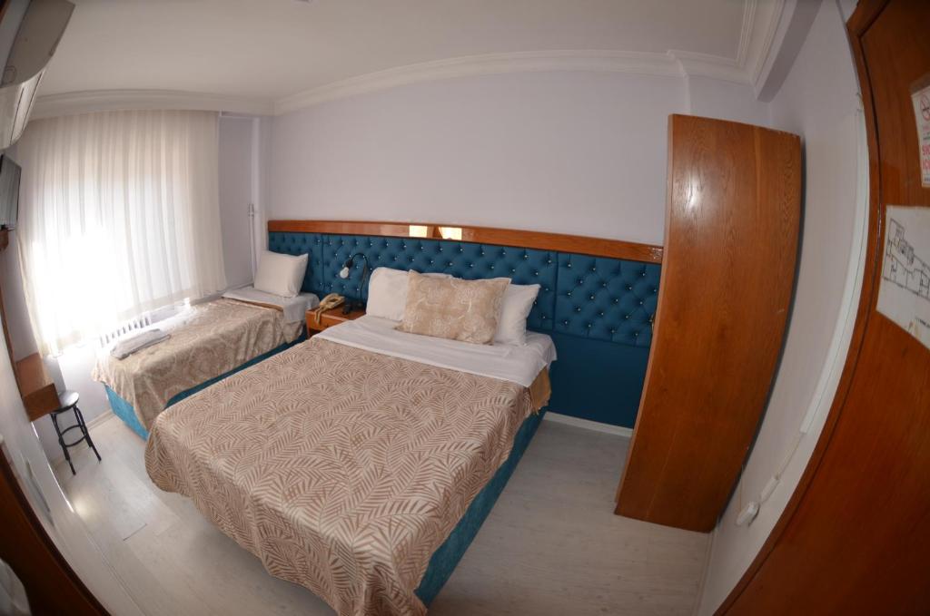 伊斯坦布尔帕多瓦酒店的一间小卧室,配有两张床和窗户