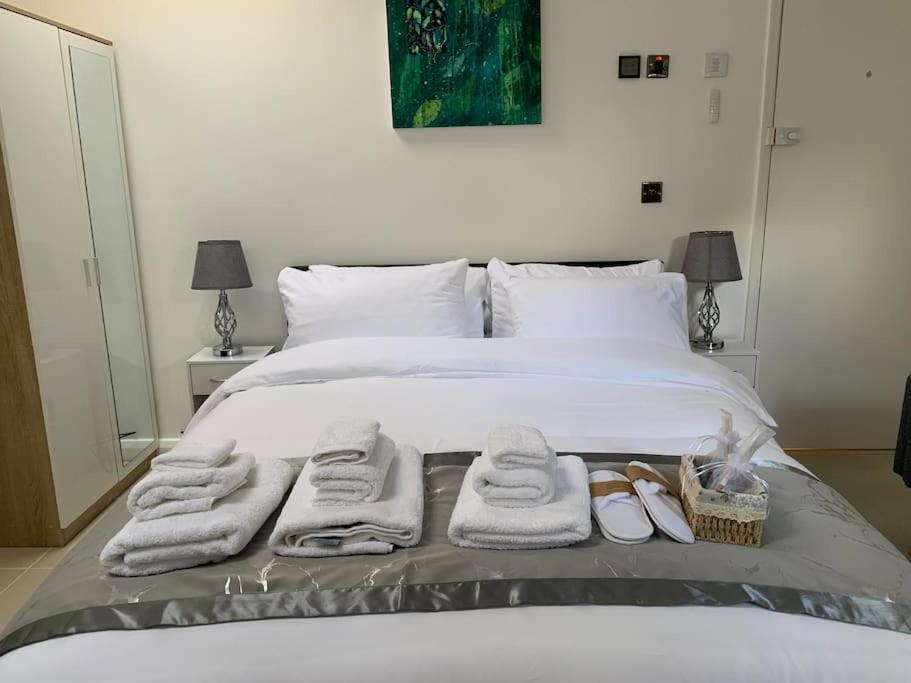 CarshaltonAnnex D. One Bedroom flat in south London的一间卧室配有带毛巾和鞋子的床