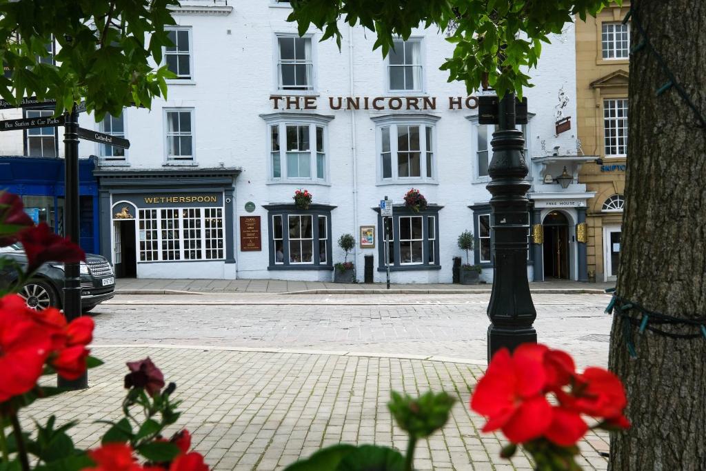 里彭The Unicorn Hotel Wetherspoon的白色建筑前的街道灯