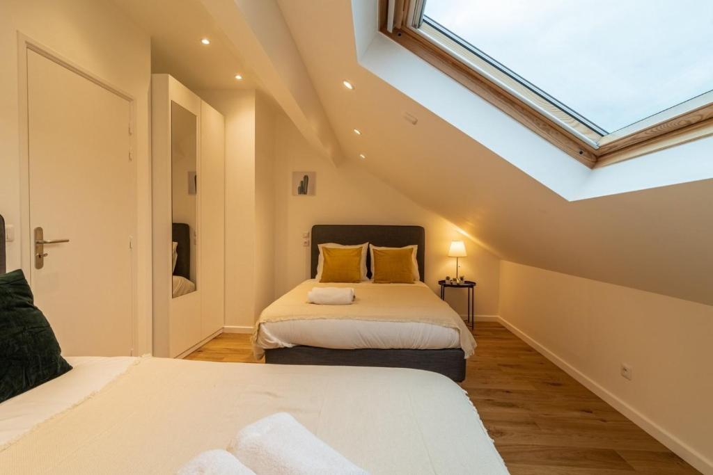 里尔Lille Centre - Nice cozy and functional ap的阁楼卧室设有两张床和天窗