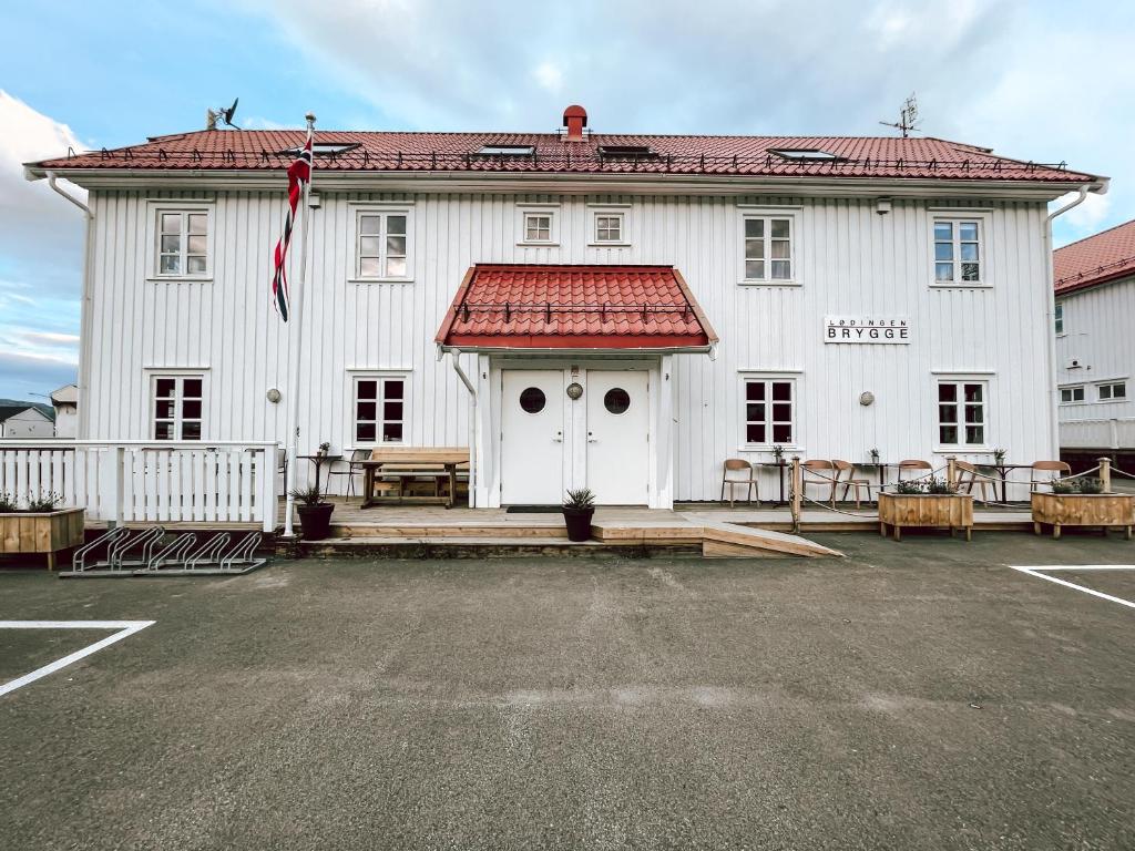 勒丁恩Lødingen Brygge的一座白色的大建筑,有红色的屋顶