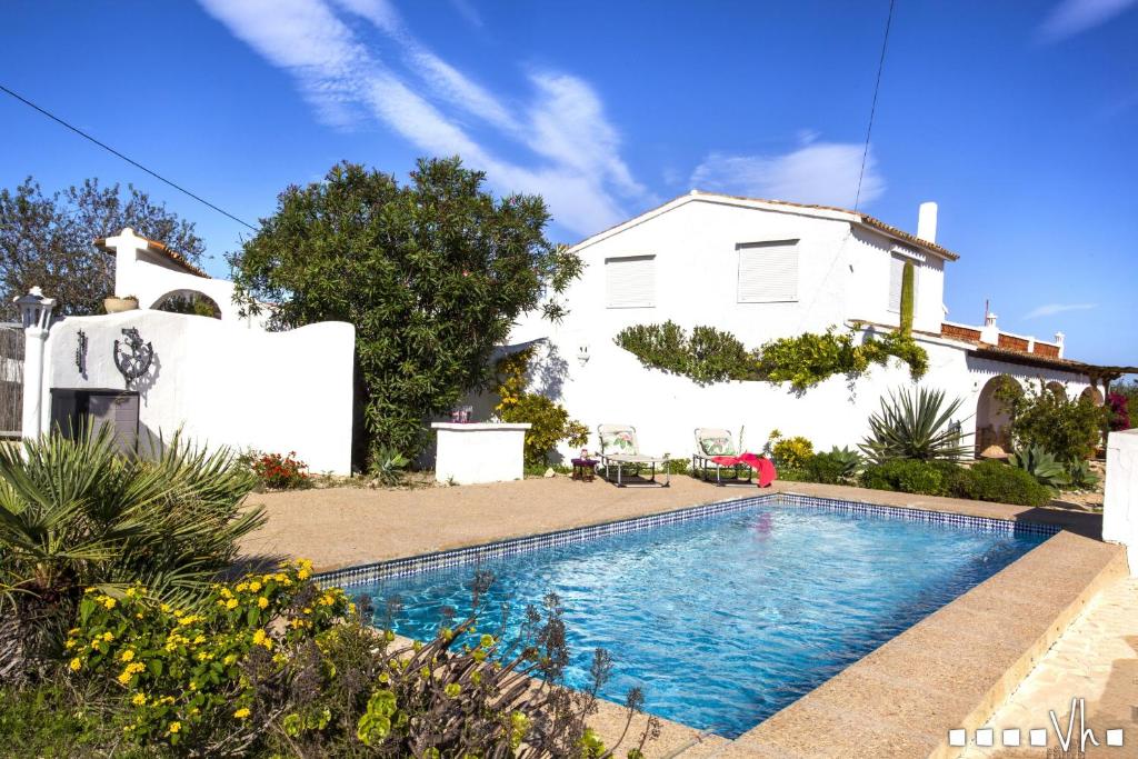 莫莱拉VH CostaBlanca - TRES PALMERAS的白色房子前的游泳池