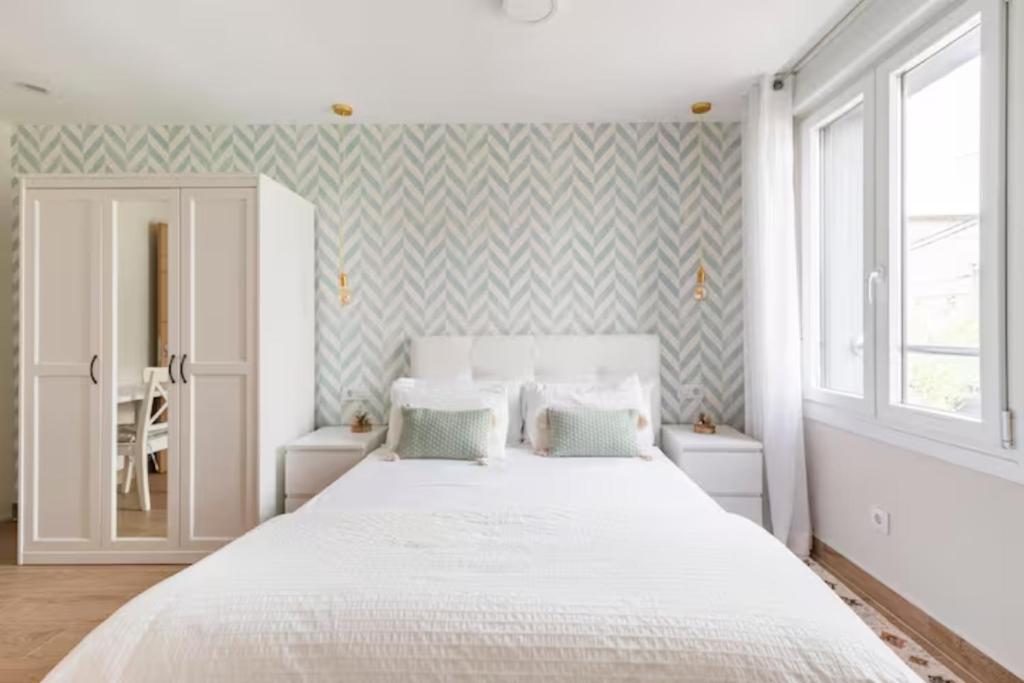 毕尔巴鄂Apartamento El Toisón de Oro 11 Garaje gratis的卧室配有一张带两个枕头的大白色床