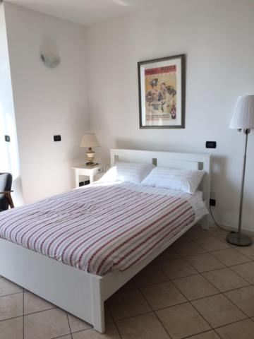 帕多瓦flat in Padova center的卧室配有带条纹毯子的白色床