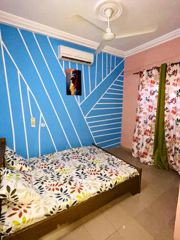 瓦加杜古Fredy meublé的一间卧室配有一张蓝色墙壁的床