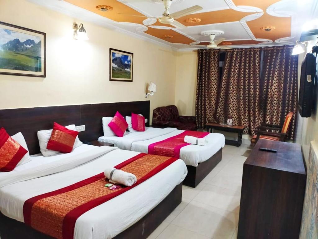 斯利那加Hotel Star of Kashmir的酒店客房 - 带两张带红色枕头的床