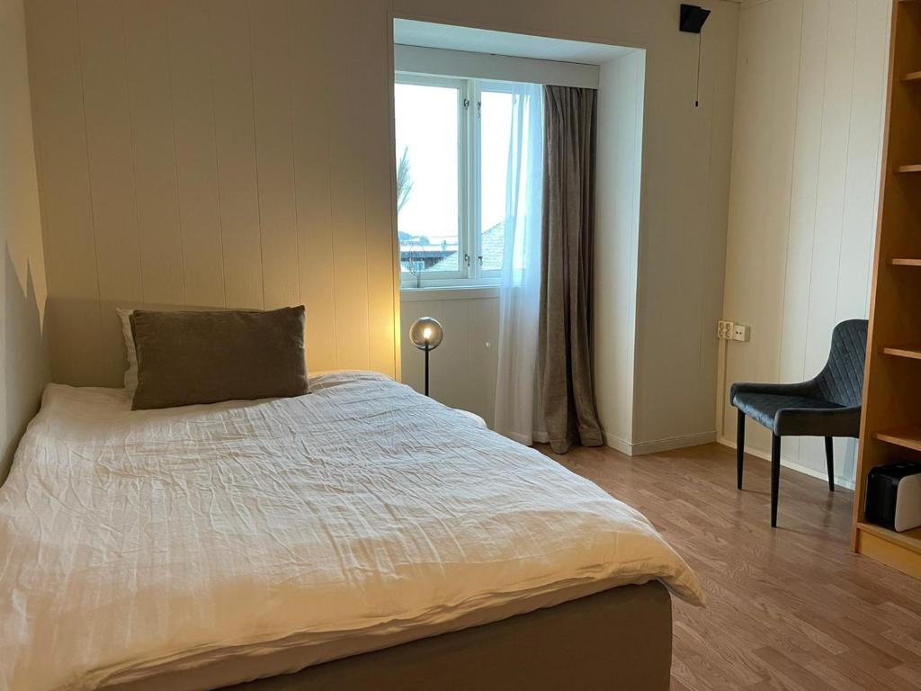 海宁格松Haugesund Urban Hotel的一间卧室配有一张带窗户和椅子的床