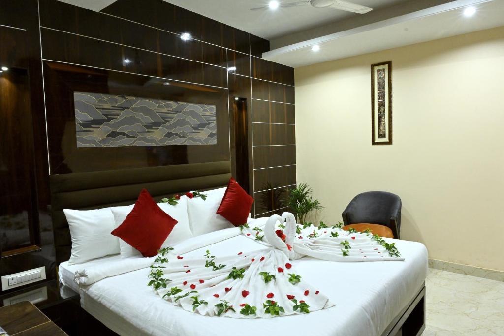 贾姆谢德布尔Hotel Trax International的卧室配有带红色枕头的大型白色床