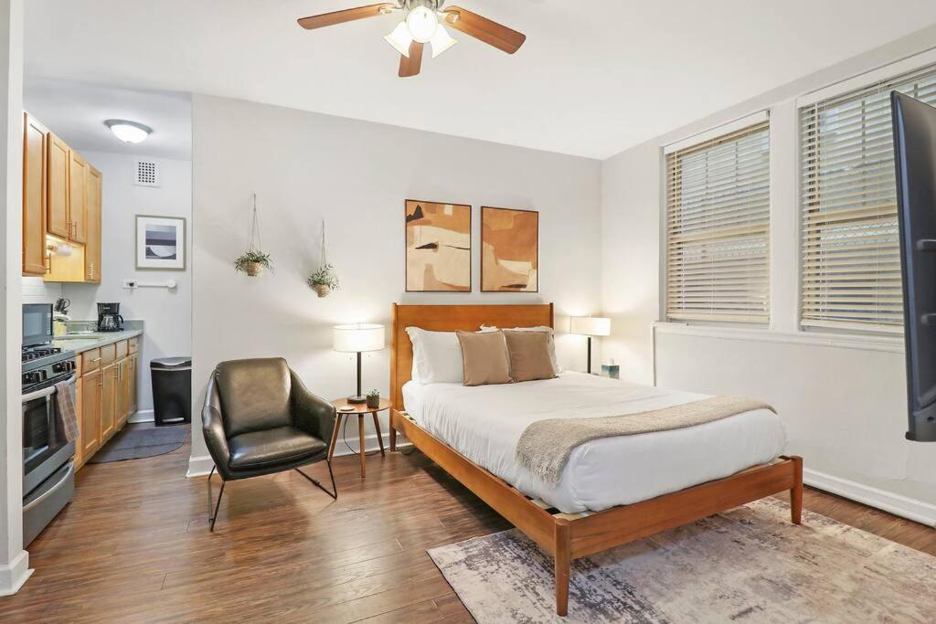 芝加哥Trendy Studio Apartment in Chicago - Kenwood 103 & 303 rep的一间卧室配有一张床和一把椅子
