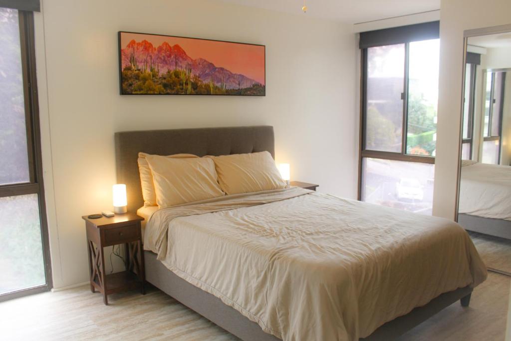 檀香山Modern Futuristic Hawaii Fortress condo的卧室配有一张床,墙上挂有绘画作品
