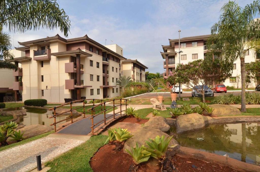 巴西利亚L209 Apto em resort beira lago com TV Smart的享有带池塘的公寓大楼的景色