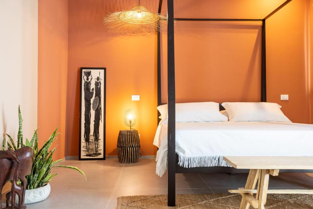 切塞纳蒂科labotanica_casalounge的一间卧室设有橙色的墙壁、一张床和一张桌子