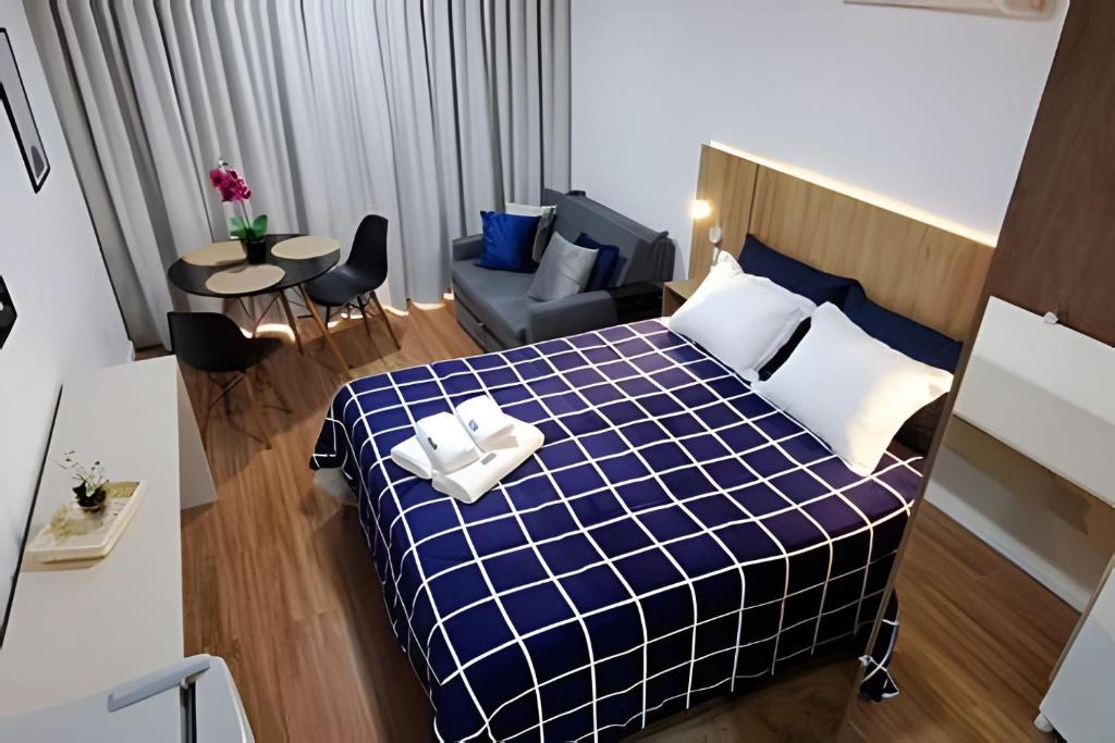 波苏斯-迪卡尔达斯Studio Pratico - Centro Poços de Caldas的卧室配有蓝色和白色的床和沙发