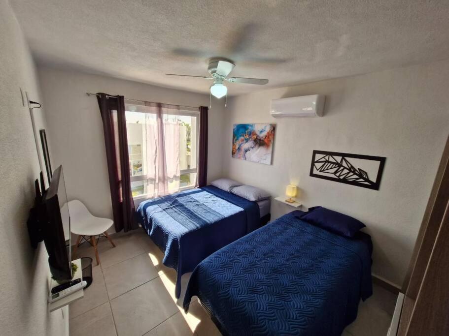 阿卡普尔科Depto. con club de Playa的一间卧室设有两张床和窗户。