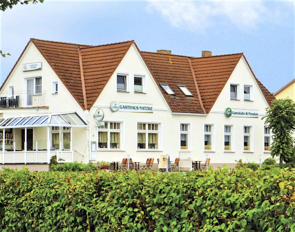 Usedom TownGasthaus & Pension Natzke的白色的大建筑,带有棕色的屋顶