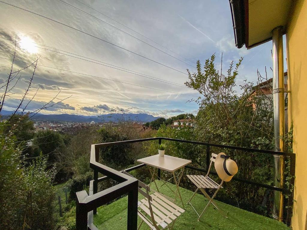 奥维多El Mirador del Naranco的设有一个配有桌子和两把椅子的阳台,并享有美景。