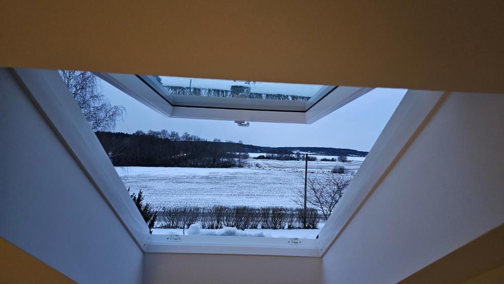 锡格蒂纳Attic floor with views over fields and sea的天窗,有雪覆盖的窗户