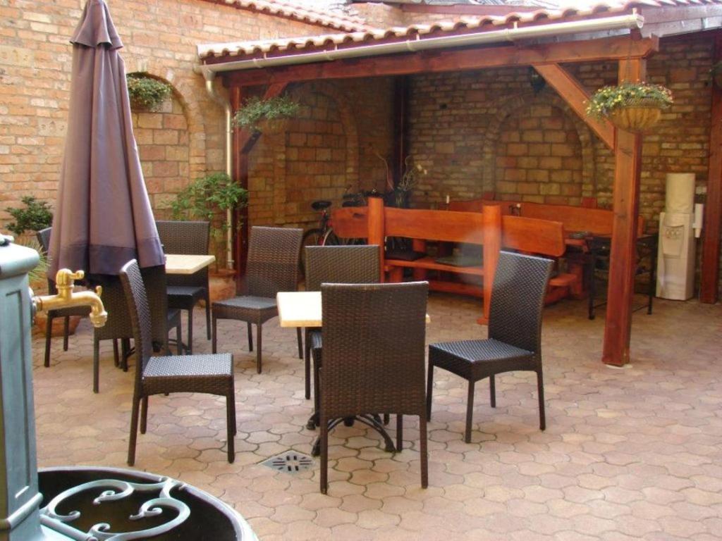 艾斯特根Arany Elefánt szálláshely的庭院配有桌椅和遮阳伞。