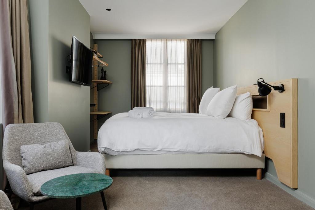 奥尔良La Loge Gogaille - 7 Dormants - Accès autonome的一间卧室配有一张床、一把椅子和电视