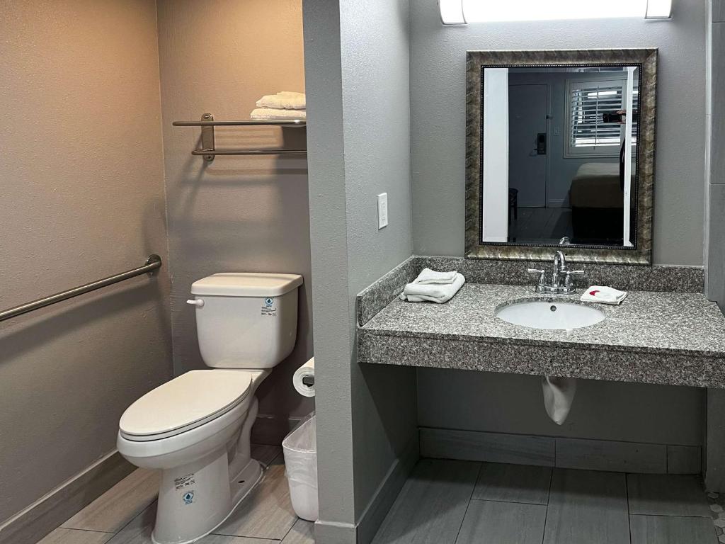 阿蒂西亚Motel 6 Artesia, CA的浴室设有卫生间和带镜子的盥洗盆