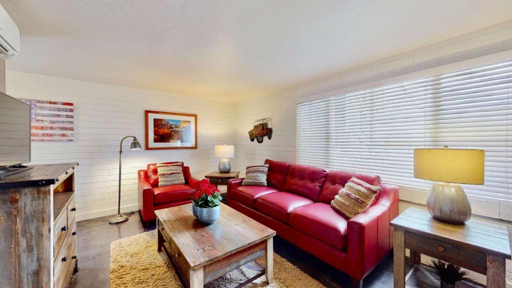 摩押Downtown Cozy Home Base - Purple Sage 2的客厅配有红色的沙发和桌子