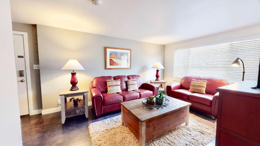 摩押Downtown Cozy Home Base - Purple Sage 5的客厅配有两张红色的沙发和一张桌子