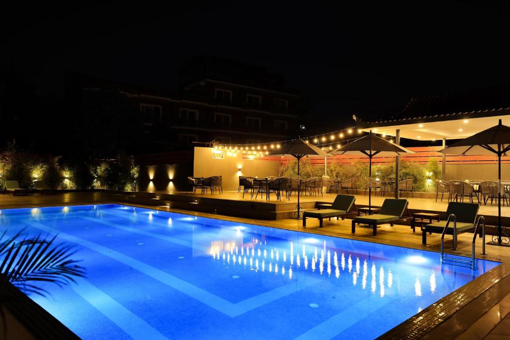 加德满都Hotel Dolmaling的一个带桌椅的夜间游泳池