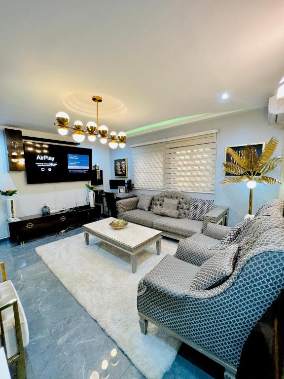 雅温得The Jumeirah Guest Home的带沙发和电视的客厅